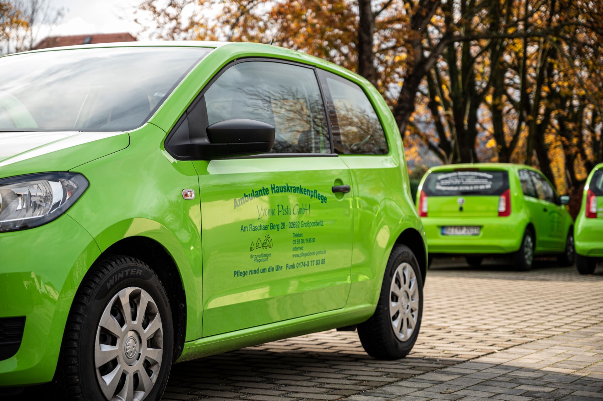 Mobile Hauskrankenpflege: Schnell und zuverlässig beim Patienten Mehrere grüne Autos, die für die mobile ambulante Hauskrankenpflege im Einsatz sind und die Erreichbarkeit der Patienten gewährleisten.